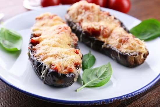 canva a dish of baked eggplants with basil leaves MAD MReyejw