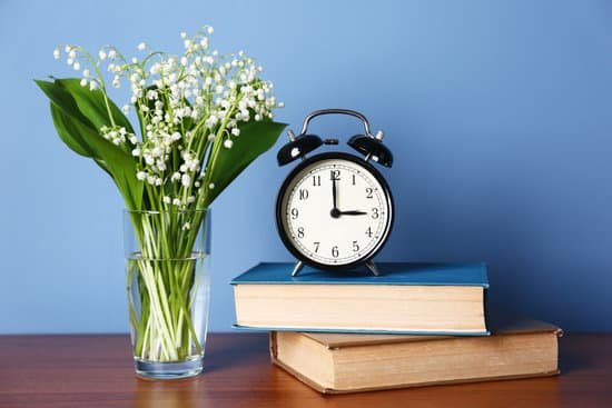 canva alarm clock with lily bouquet on table MAD QhjI6K0