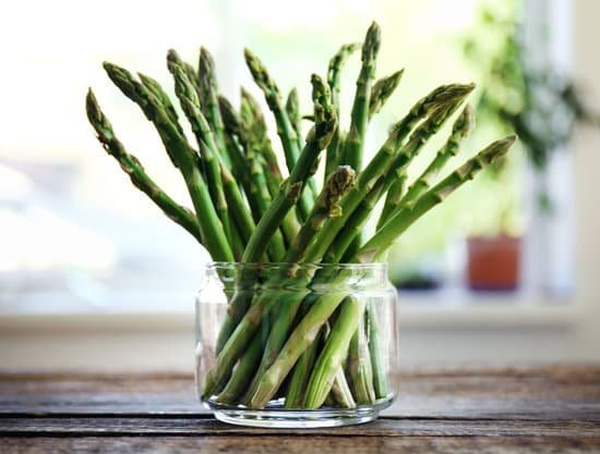 canva asparagus in glass jar on wooden table MAD QiHvm0c