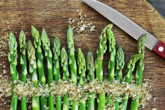 canva asparagus with knife and sea salt on cutting board MAD Qgq2SEU