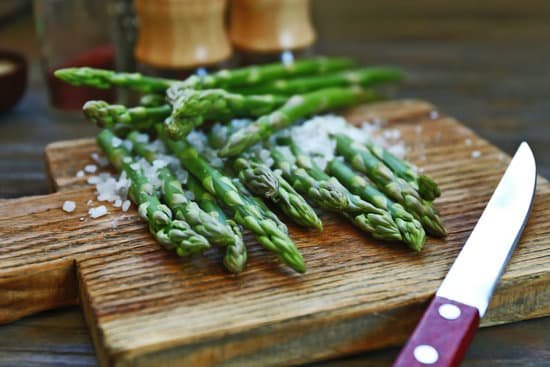 canva asparagus with knife and sea salt on cutting board MAD QlgoW2w