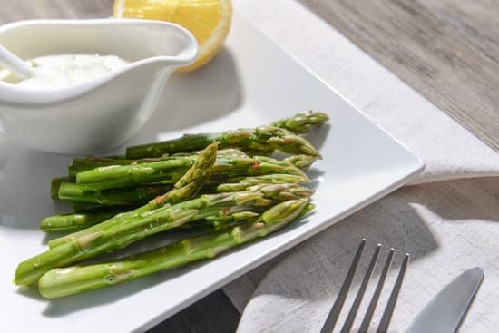 canva asparagus with lemon and sauce on plate MAD QpbRk5s