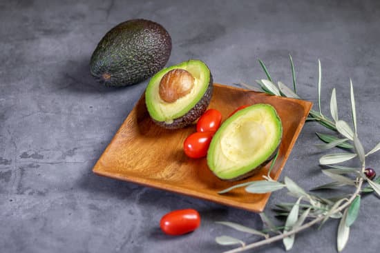 canva avocado halves and tomatoes on wooden plate MAEQuIo 9cU