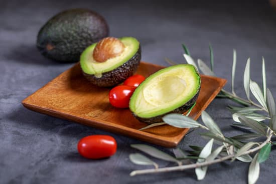 canva avocado halves and tomatoes on wooden plate MAEQuJB1aJ8