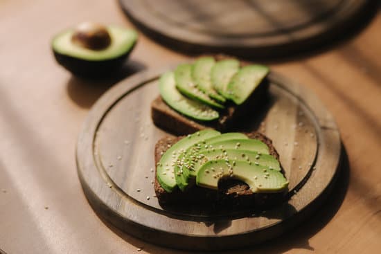 canva avocado sandwich on wooden plate MAERFTOahNo