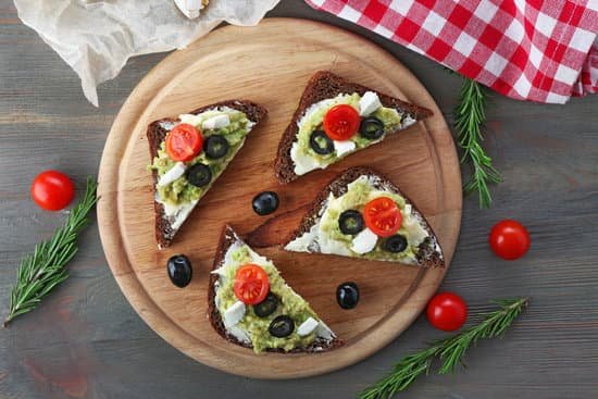 canva avocado sandwiches with tomatoes and olives on cutting board MAD QuL3boY