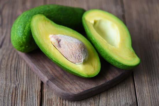 canva avocado sliced in half on wooden cutting board MAD 3mcZ660