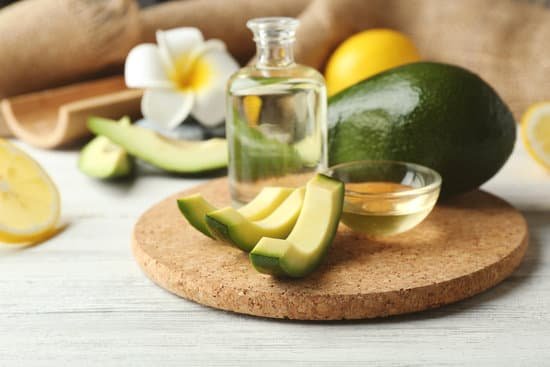 canva avocado with oil on wooden table MAD