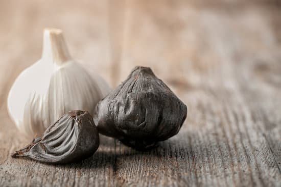 canva black and white garlic bulbs on wooden table MAD8ShmYuPY