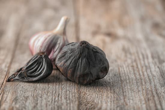 canva black and white garlic bulbs on wooden table MAD8Su7jm g