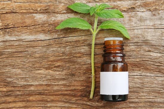 canva bottle and herbs on wooden background MAD QwiFV5o