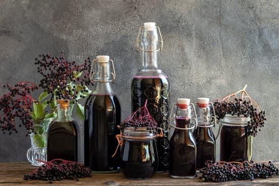 canva bottles of black elder syrup with fresh elderberries MAEcEpaTDq4