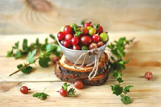 canva bowl of gooseberries on wooden surface MAEBYmmMnGo