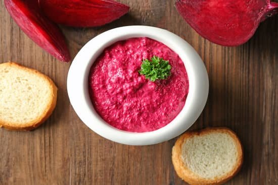 canva bowl with creamy beet hummus on wooden background MAD9bmCduEE
