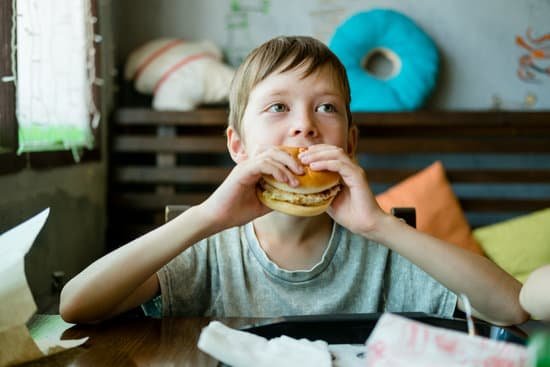 canva boy eating a big burger with a cutlet. hamburger in the hand MAErkC8RBOc