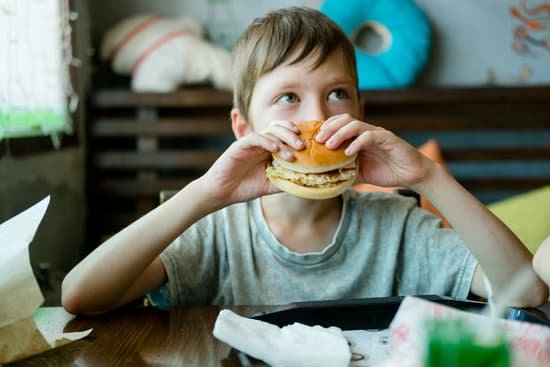 canva boy eating a big burger with a cutlet. hamburger in the hand MAErkIGWlO8