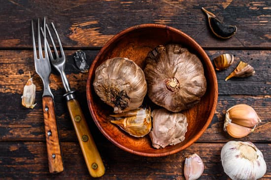canva bulbs of garlic in a wooden bowl and forks MAEQrWLjGeY
