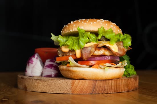 canva burger with bacon and lettuce on wooden board MAEOUEFtK c