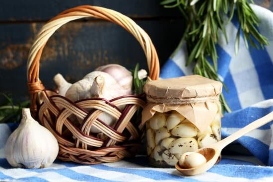 canva canned garlic in glass jar and wicker mat and rosemary MAD MKOavco