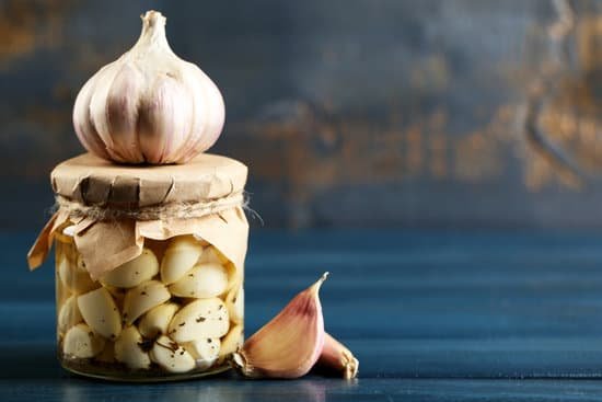 canva canned garlic in glass jar on color wooden background MAD