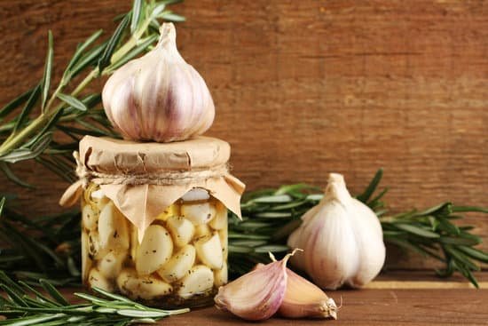 canva canned garlic in glass jar on wooden background MAD MEBctsE