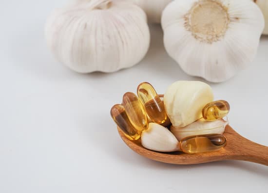 canva capsule garlic oil and fresh garlic in wooden spoon MAERD OS Jw