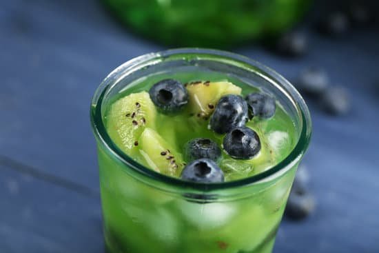 canva close up of glass of cold beverage with kiwi and blueberries MAD MmiqRDM