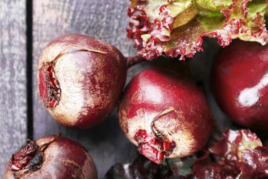 canva close up of red beets with lettuce on wooden table MAD MRGDHuQ