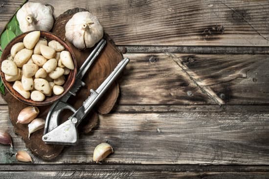 canva cloves of fresh garlic with garlic press copy space MAEPHAoGkrw