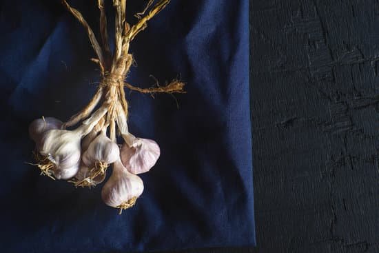 canva cluster of garlic bulbs on a blue cloth MAEHTwFAwGE