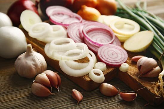 canva composition of onions and garlic on wooden background MAD M8R6PvA