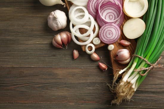 canva composition of onions and garlic on wooden background MAD Mz5amAc