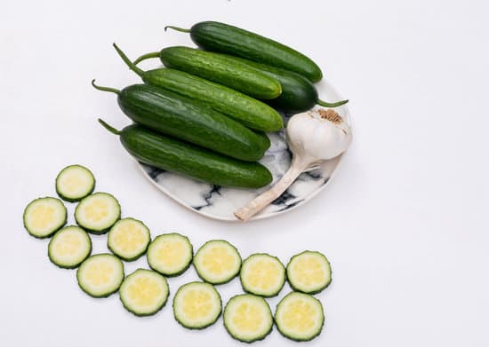 canva cucumbers and garlic on plate with sliced cucumbers isolated on white MAD gV0GjTQ