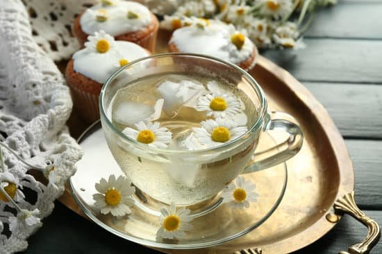 canva cup of chamomile tea with chamomile flowers and tasty muffins MAD MeIVTdw