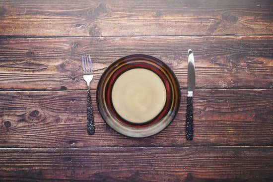 canva cutlery and empty plate on wooden background top down MAEoq9biQEo