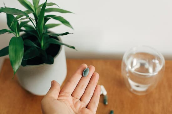 canva dietary supplements. hand holding chlorophyll tablet above glass MAEYTYlkFIs