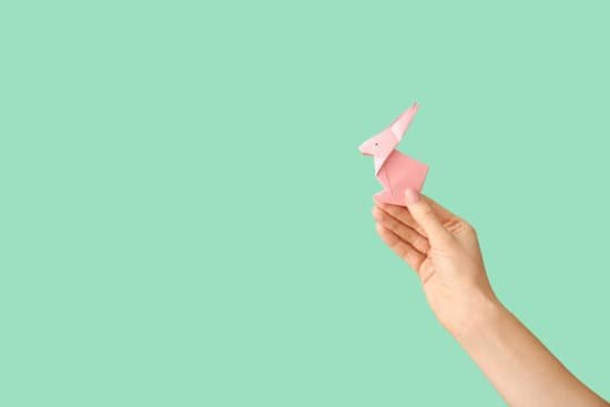 canva female hand with origami rabbit on color background MAEGI rCokk
