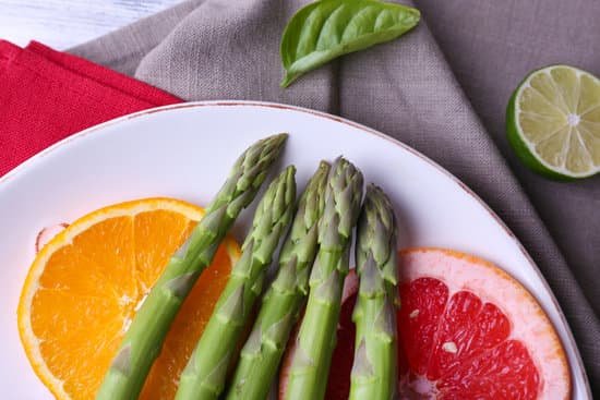 canva fresh asparagus and slices of citrus fruits on a plate MAD