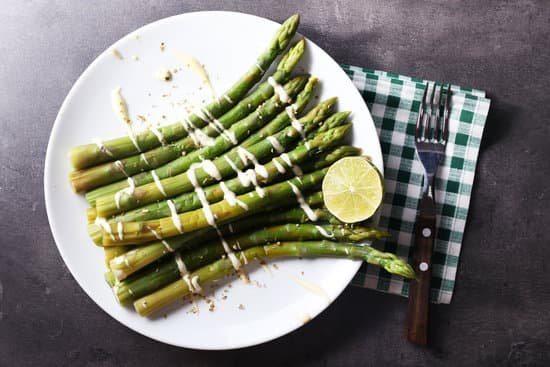 canva fresh asparagus with lime on white plate MAD MpOzGzs