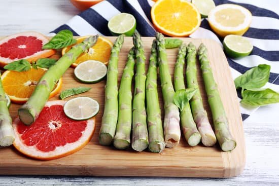 canva fresh asparagus with slices of citrus fruits on cutting board MAD MdbVVFw