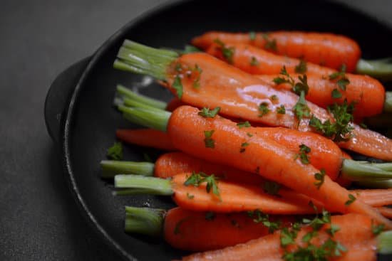 canva fresh baby carrots with herbs in pan close up MAD Q9ymKaA
