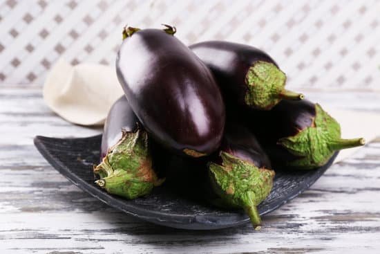 canva fresh eggplants on a wooden table MAD Md6bR o