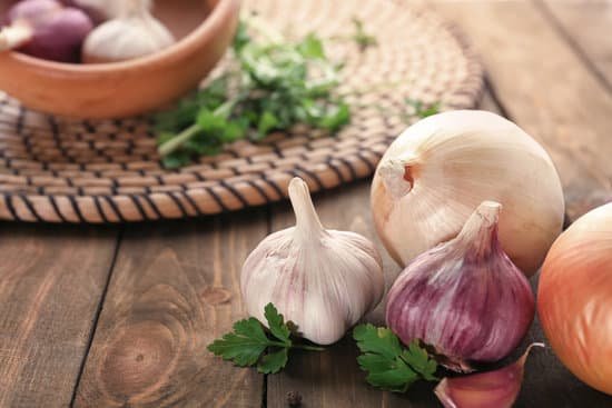 canva fresh garlic and onion on a wooden table MAD8Si4hl58