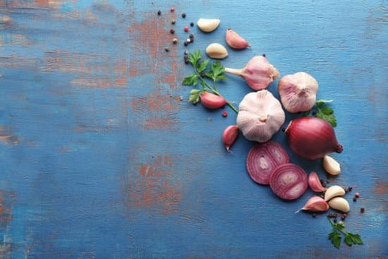 canva fresh garlic and onion on blue table flatlay MAD8SicyPP0