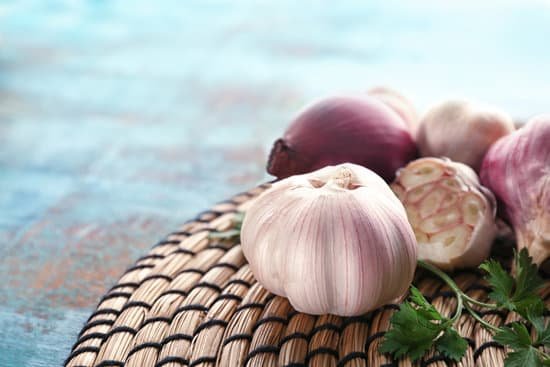 canva fresh garlic onion and parsley on woven mat on table MAD8Sn9opjw