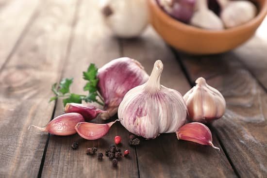 canva fresh garlic peppercorns and parsley on wooden table closeup MAD8So6vt7A