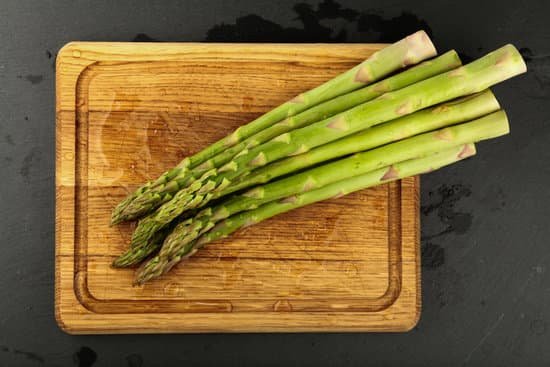 canva fresh green asparagus on wooden cutting board MAEEE2vSaTk