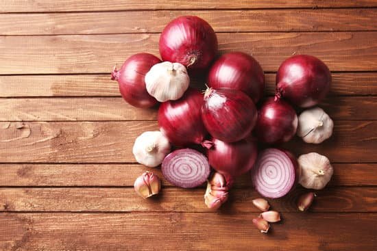 canva fresh red onions with garlic on wooden background MAD M9M0K1Q