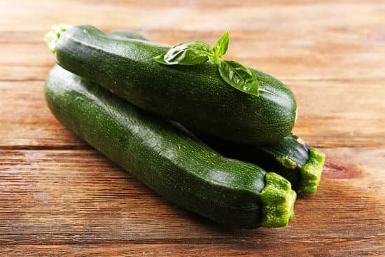 canva fresh zucchini with basil on wooden table close up MAD