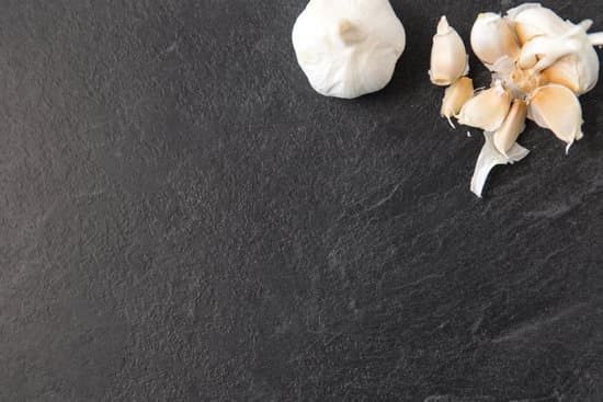 canva garlic and cloves on slate stone background MAEQQqL9Npk